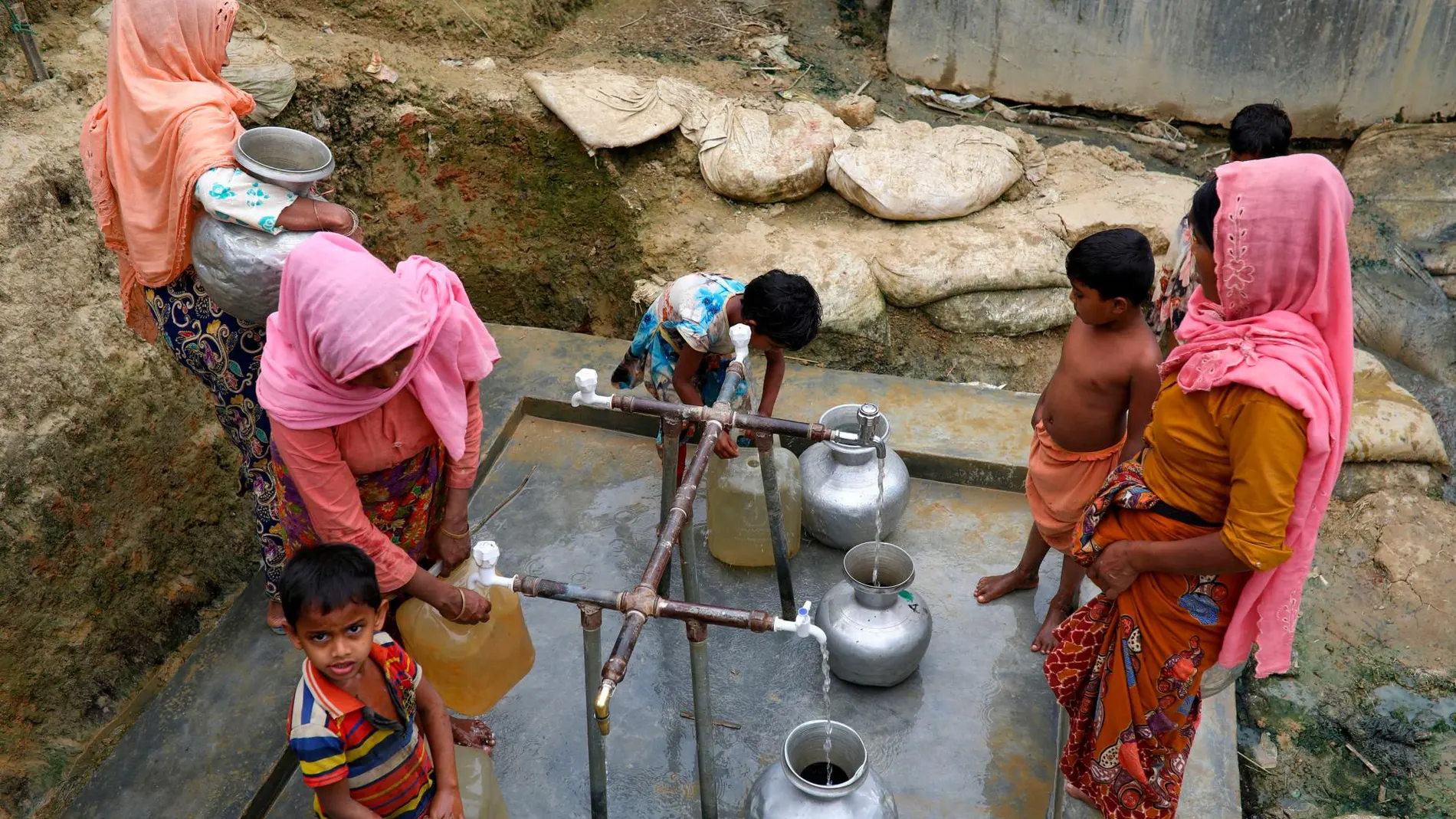 Mujeres de Bangladesh junto a sus hijos cogiendo agua