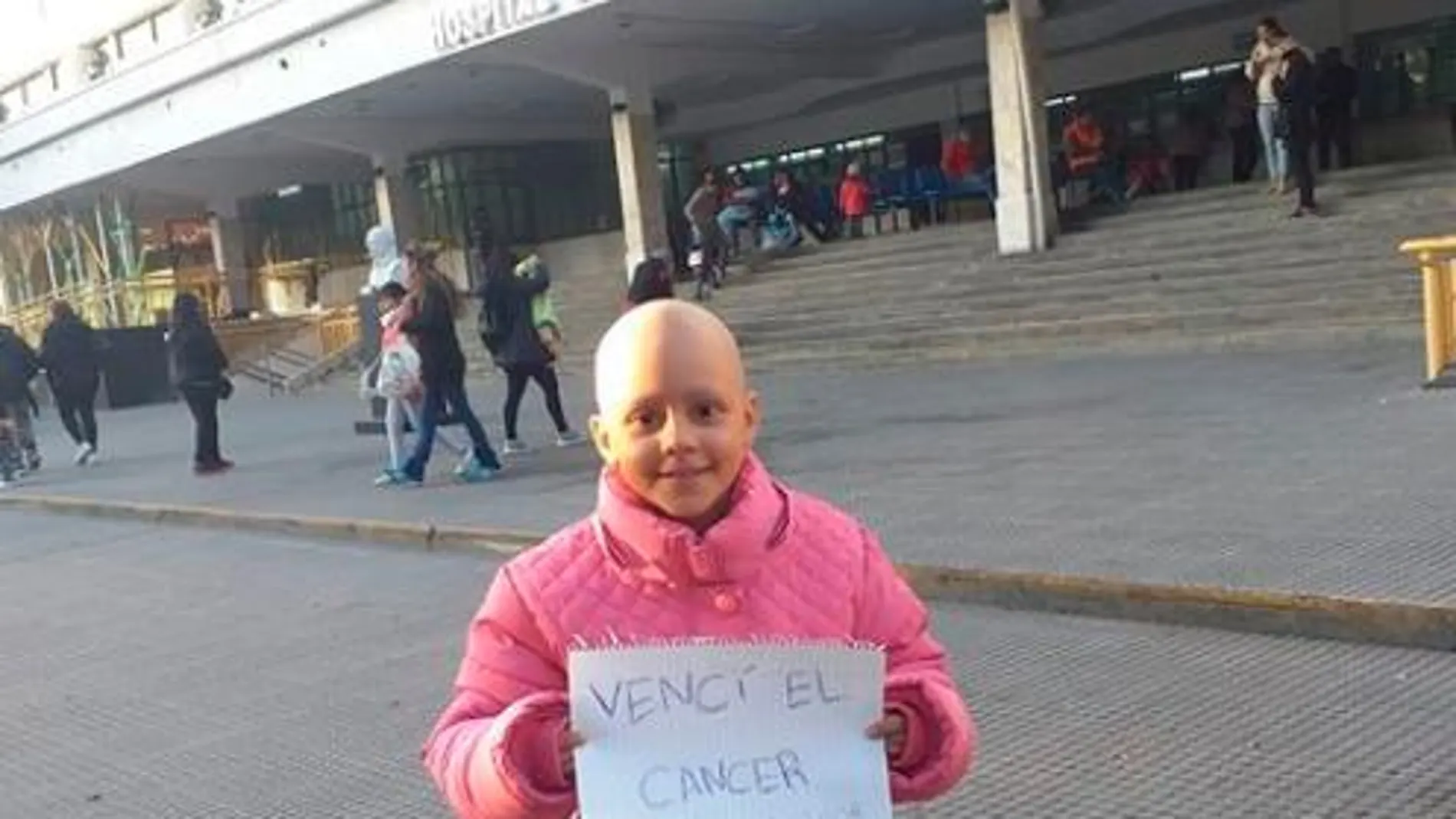 Delfina con un cartel en el que confirma la superación del cáncer