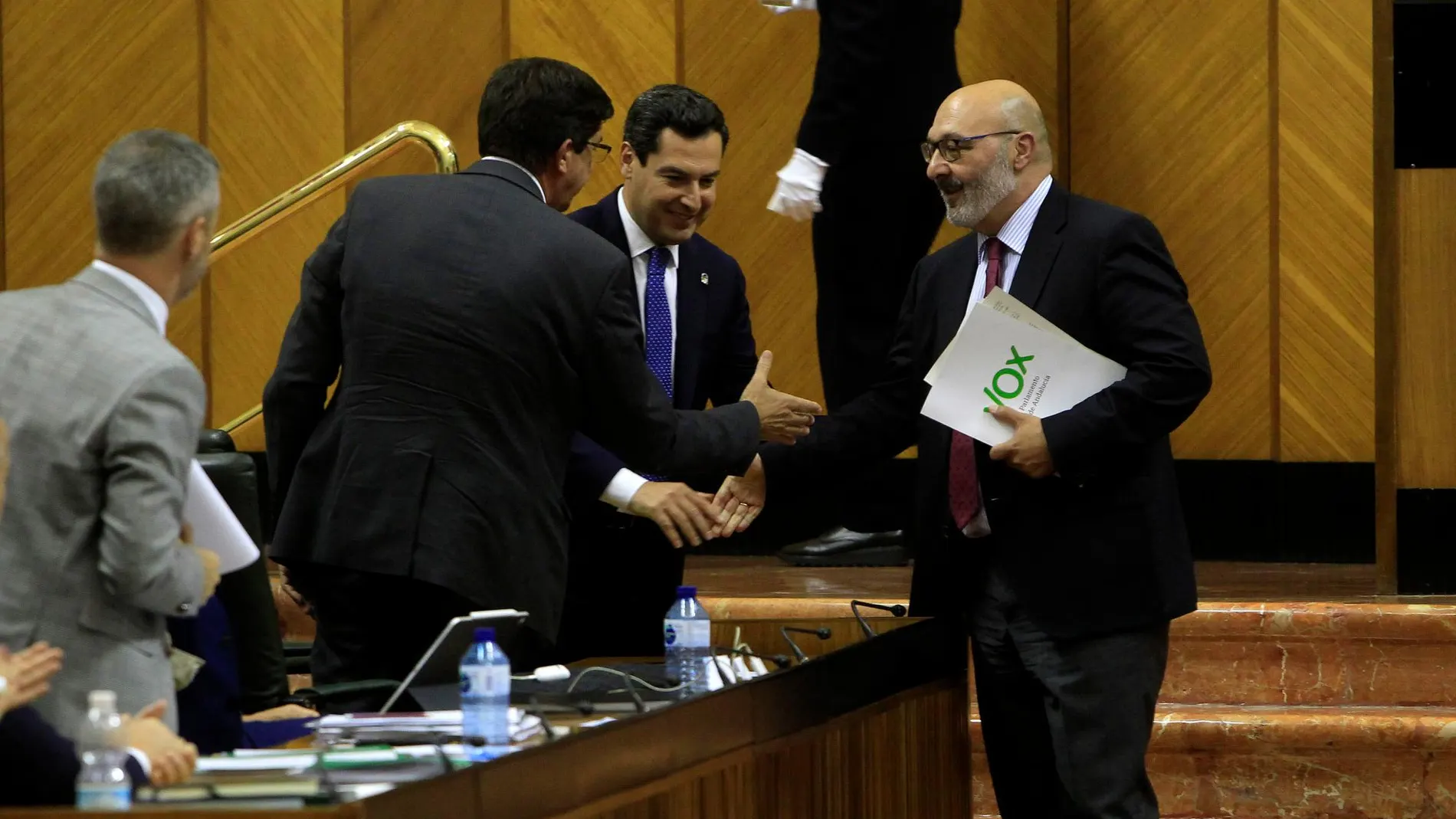 Alejandro Hernández saluda a Juan Marín y a Juanma Moreno en el Parlamento, tras aprobarse las cuentas de este ejercicio / Foto: Manuel Olmedo