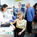 Una trabajadora del Centro de Salud del barrio de Cazoña, vacuna a la ministra de Sanidad en funciones, María Luisa Carcedo de la gripe
