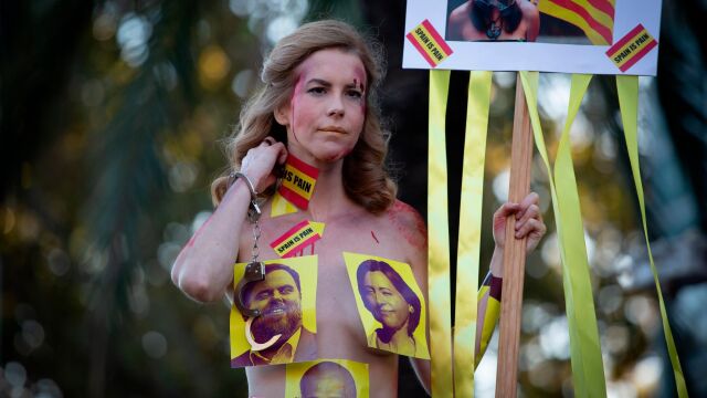 Una mujer tan sólo cubierta por fotografías de los políticos presos, en la marcha independentista de Barcelona/Foto: Ep