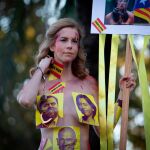 Una mujer tan sólo cubierta por fotografías de los políticos presos, en la marcha independentista de Barcelona/Foto: Ep