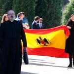 Familiares de Franco salen con la bandera con la que han cubierto el ataúd durante la misa/Foto: C. Bejarano