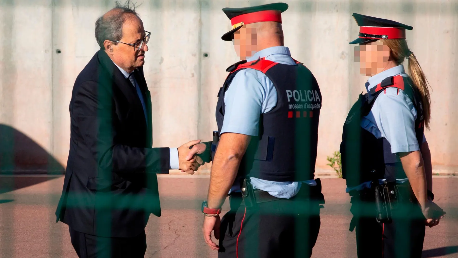El presidente de la Generalitat, Quim Torra, saluda a dos Mossos d'Esquadra en una imagen de archivo/ep