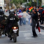 Policías en moto usan gas esprays de pimienta contra los manifestantes.