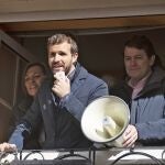 Pablo Casado se dirige desde un balcón de la Calle Mayor de Palencia a los simpatizantes del PP en presencia de la candidata Milagros Marcos, mientras Fernández Mañueco sujeta el megáfono para que se escucharan bien los mensajes