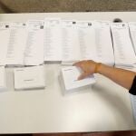 Una persona coloca las listas con las diferentes candidaturas que concurren a las elecciones generales que se celebran mañana durante el montaje del colegio electoral en el CEIP Pi i Margall de Madrid. EFE/J.J. Guillén