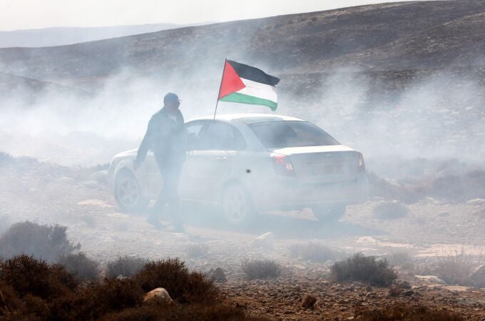 Un hombre ondea la bandera palestina entre gas lacrimógenos. EFE/ Abed Al Hashlamoun