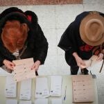 Dos personas eligen sus papeletas en un colegio electoral de Pamplona en las elecciones generales del 10-N. EFE/ Villar López