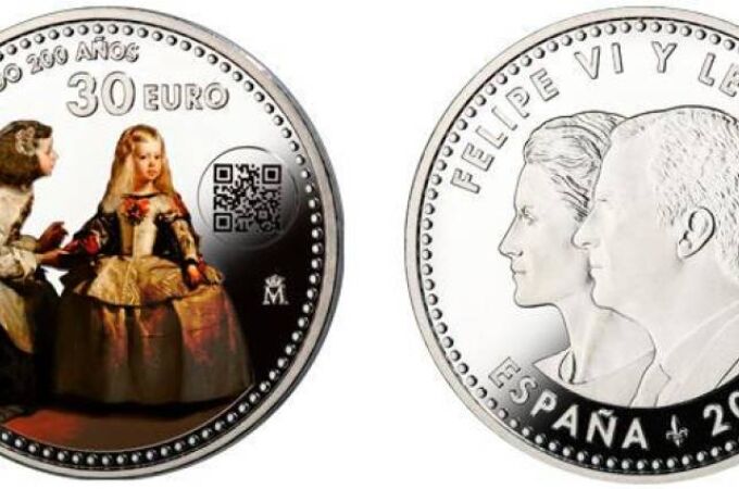 El reverso, ocupando la parte central de la moneda, presenta un detalle a color del lienzo “Las Meninas”, de Velázquez, En el anverso se reproducen las efigies acoladas de los Reyes
