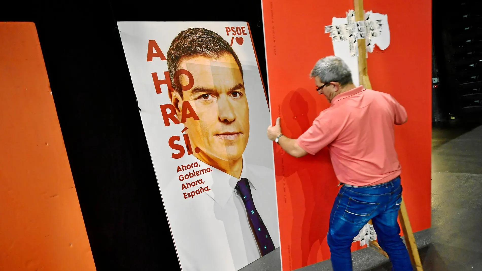Imagen de un operario colocando un cartel de Pedro Sánchez en Pamplona