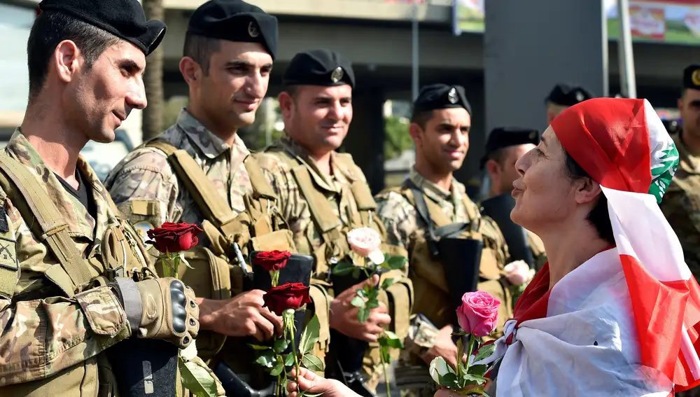 Una manifestante ofrece una flor a uno de los militares que montan guardia en el área de Chevrolet, próxima a Beirut