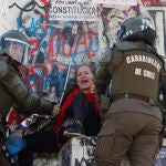 Los carabineros chilenos agarran a un manifestante herido en Santiago
