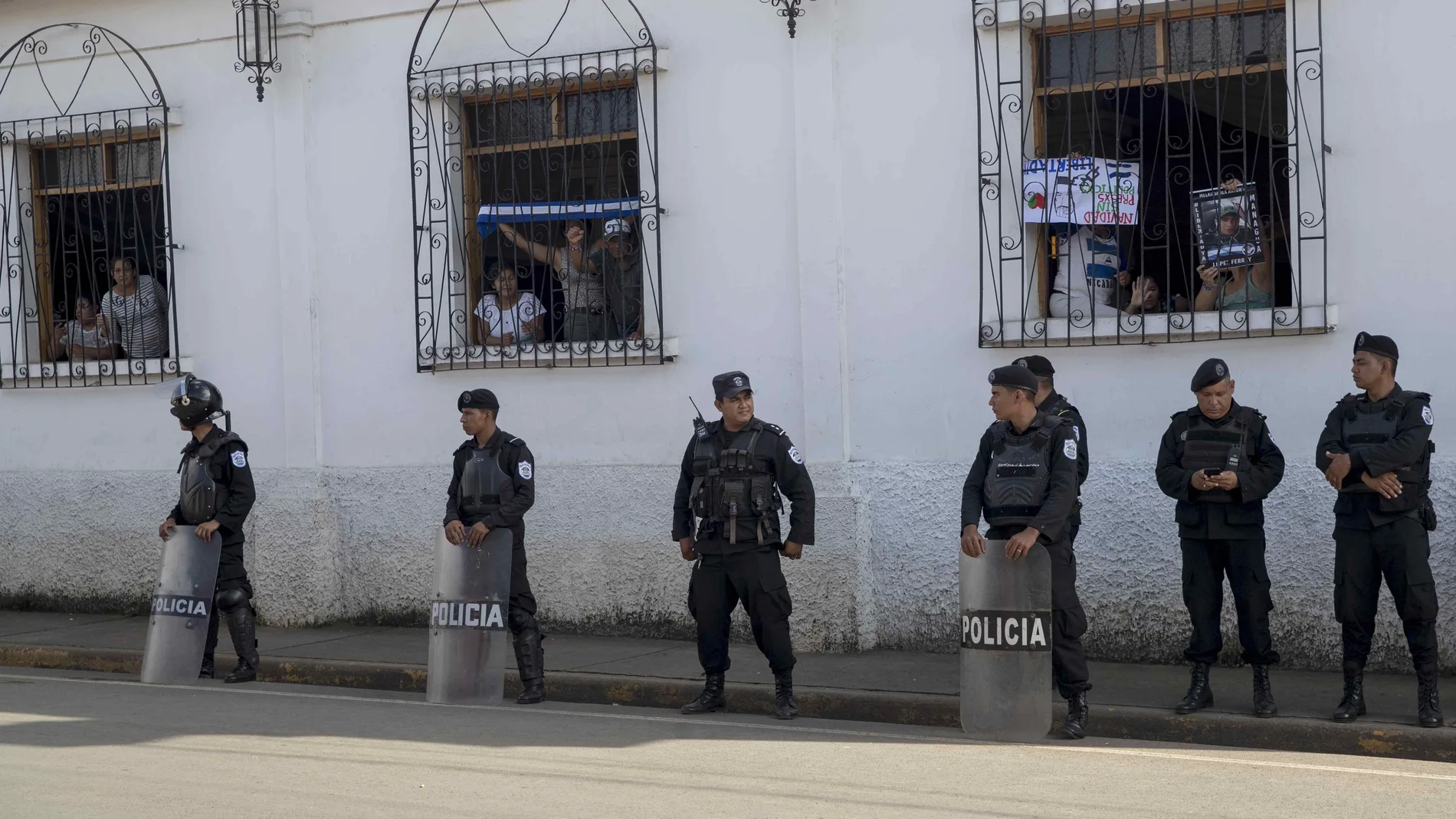 Varios agentes antidisturbios forman un cordón de seguridad al frente de la iglesia San Miguen Arcángel este viernes, en la ciudad de Masaya (Nicaragua). Un cerco policial que ha dejado sin suministros de agua ni luz a los manifestantes en el interior, por decisión del Gobierno.