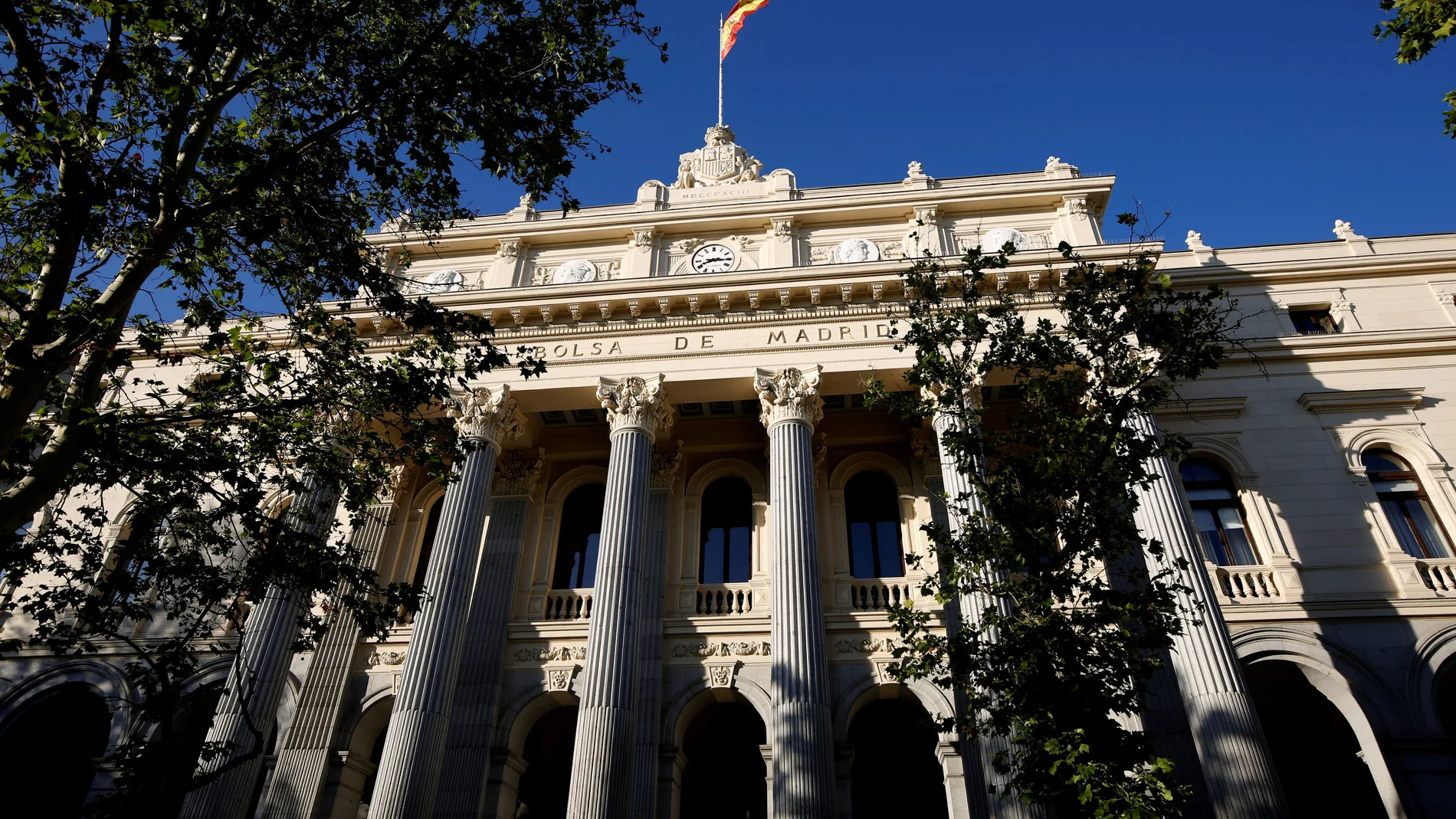 FILE PHOTO: A Spanish flag flutters above the Madrid Bourse