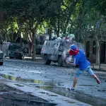 Un manifestante lanza una piedra un coche de la policía en Chile23/11/2019 ONLY FOR USE IN SPAIN