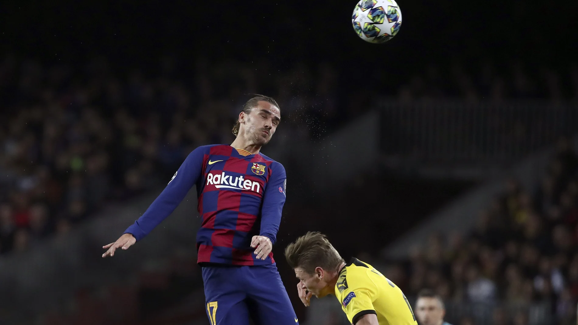Barcelona's Antoine Griezmann heads the ball above Dortmund's Lukasz Piszczek, right, during a Champions League group F soccer match between Barcelona and Dortmund at the Camp Nou stadium in Barcelona, Spain, Wednesday, Nov. 27, 2019. (AP Photo/Emilio Morenatti)