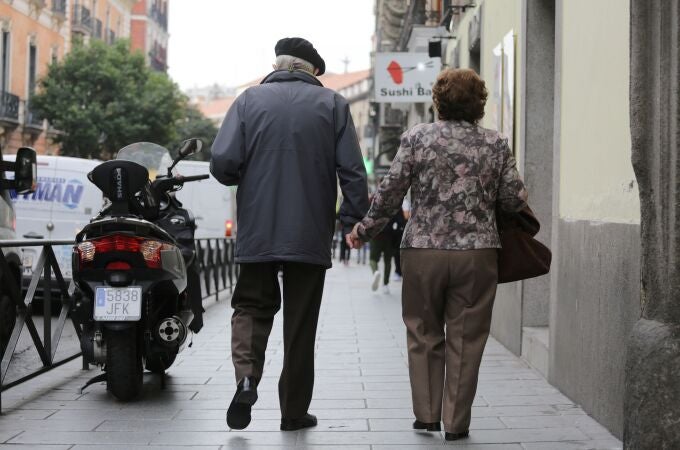 Una pareja de pensionistas pasea por la calle