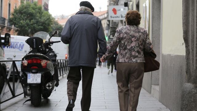 Una pareja de pensionistas pasea por la calle