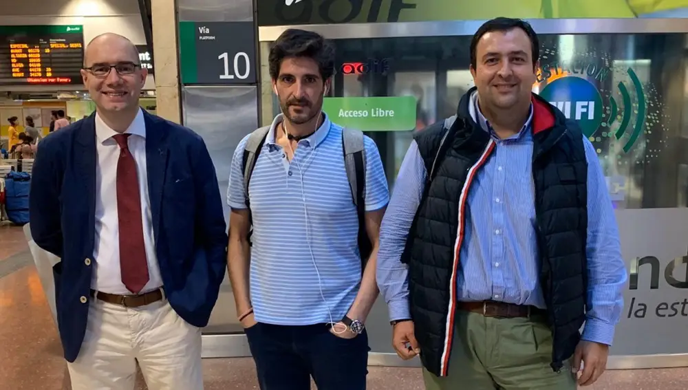 Tres integrantes de la Asociación de Usuarios de AVE de Valladolid esperen la salida de su tren en la estación de Chamartín