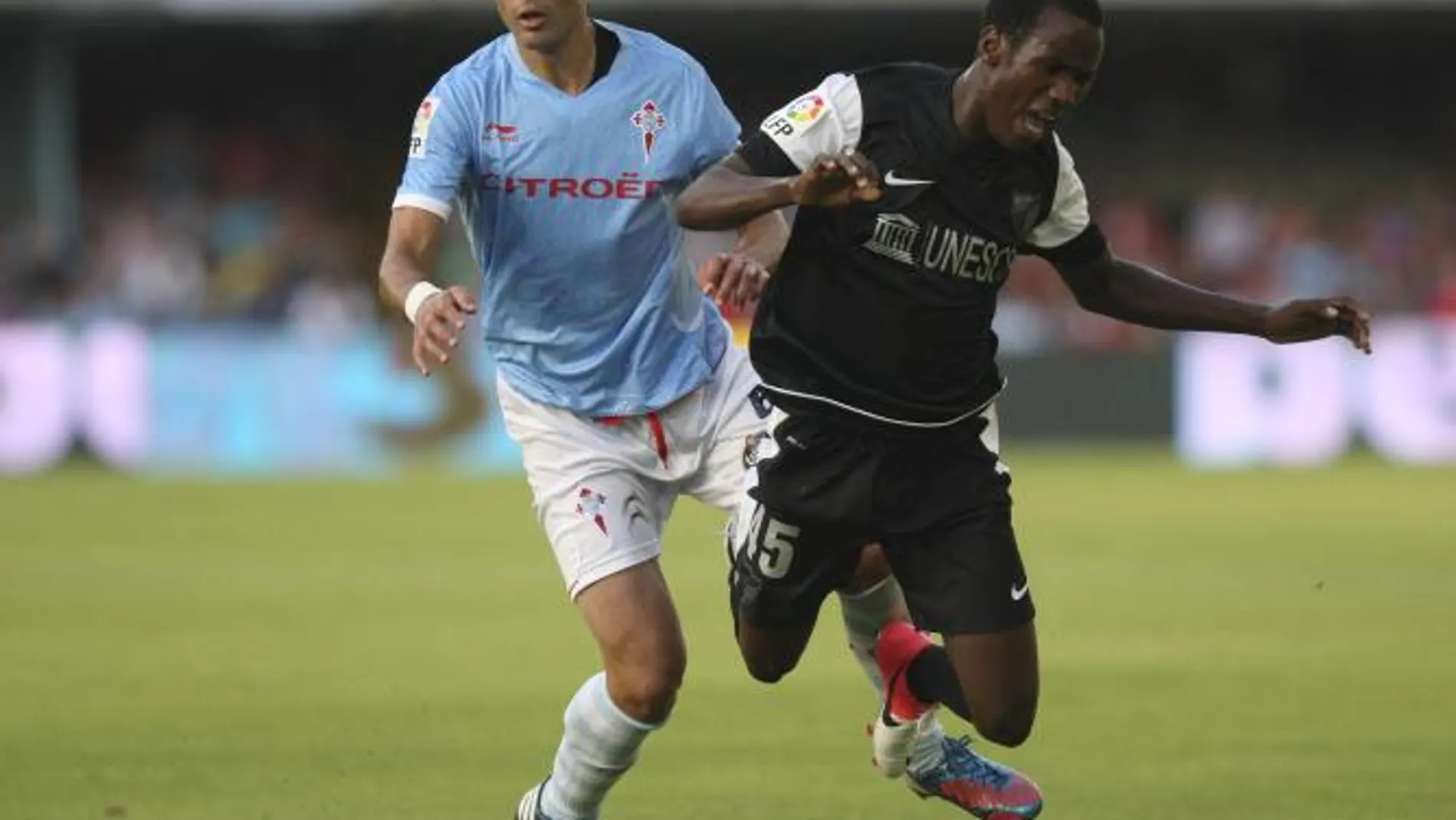 El centrocampista del Celta, Borja Oubiña (i), presiona al delantero camerunés del Málaga CF, Fabrice Olinga