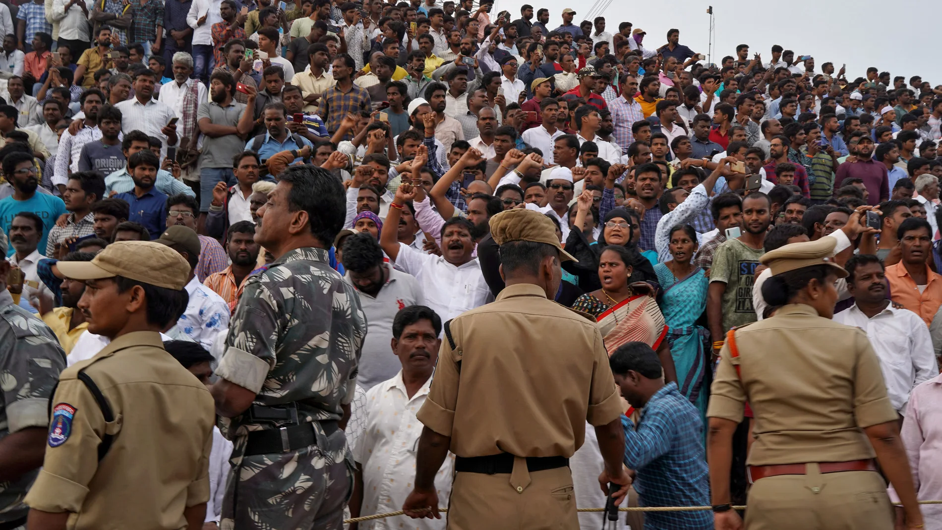 People shout slogans as they gather at the site where police shot dead four men suspected of raping and killing a 27-year-old veterinarian, in Chatanpally on the outskirts of Shadnagar town