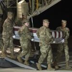 Un equipo de transporte de la Fuerza Aérea mueve una caja de transferencia que contiene los restos del Alférez de la Armada Joshua Watson el domingo 8 de diciembre de 2019, en la Base Dover de la Fuerza Aérea, / AP