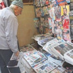 Un argelino echa un vistazo a las portadas de los periódicos en un kiosco un día después de las elecciones presidenciales