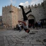 Un joven palestino salta frente a la Puerta de Damasco en Jerusalén/EFE