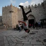 Un joven palestino salta frente a la Puerta de Damasco en Jerusalén/EFE