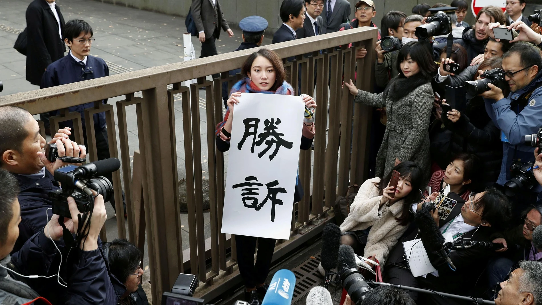 Japanese journalist Shiori Ito holds a banner reading "Victory" outside the Tokyo District Court after a court verdict in Tokyo