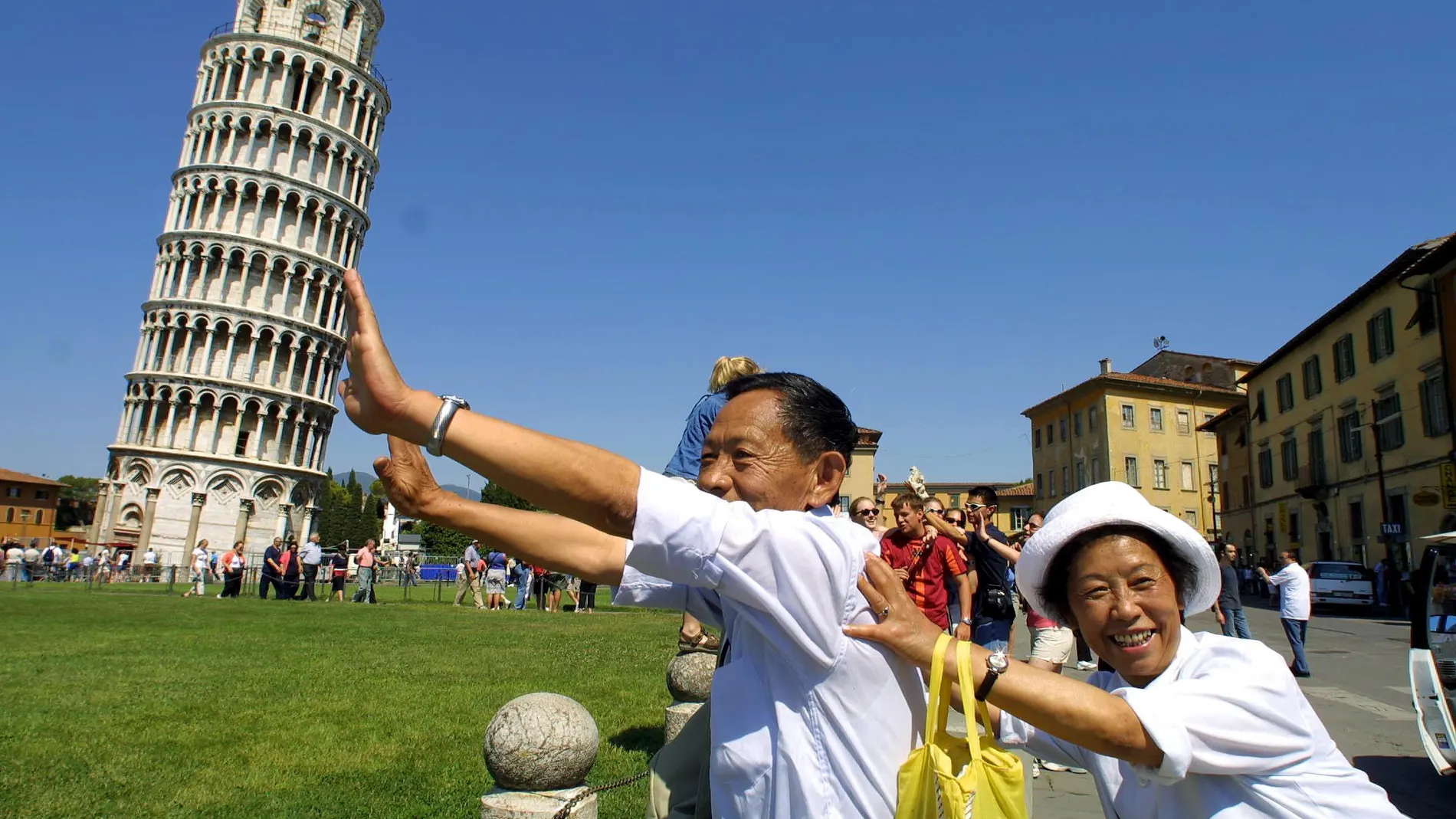 Dos turistas chinos se sacan una fotografía con la Torre de Pisa