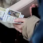 Una mujer compra varios boletos de la Lotería del Niño.