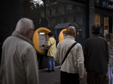Imagen de archivo de varias personas haciendo cola en el cajero de una entidad bancaria