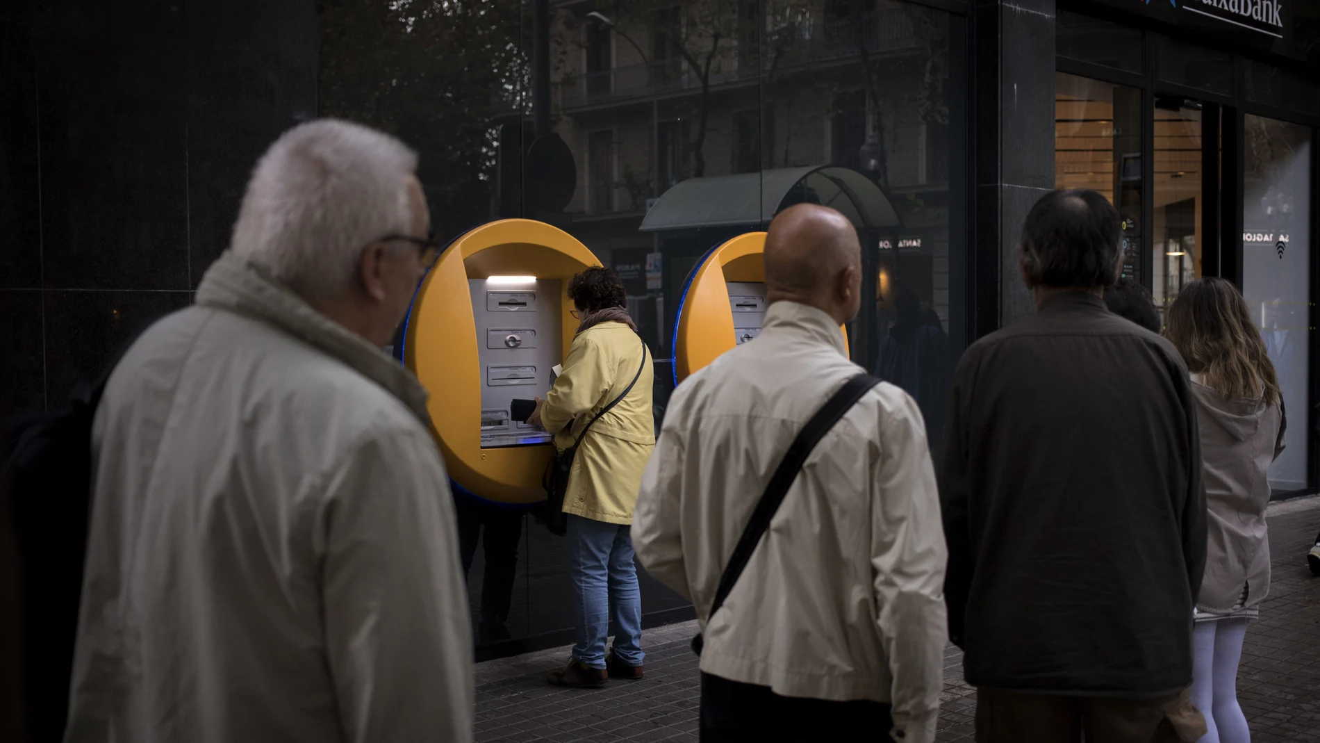 Imagen de archivo de varias personas haciendo cola en el cajero de una entidad bancaria
