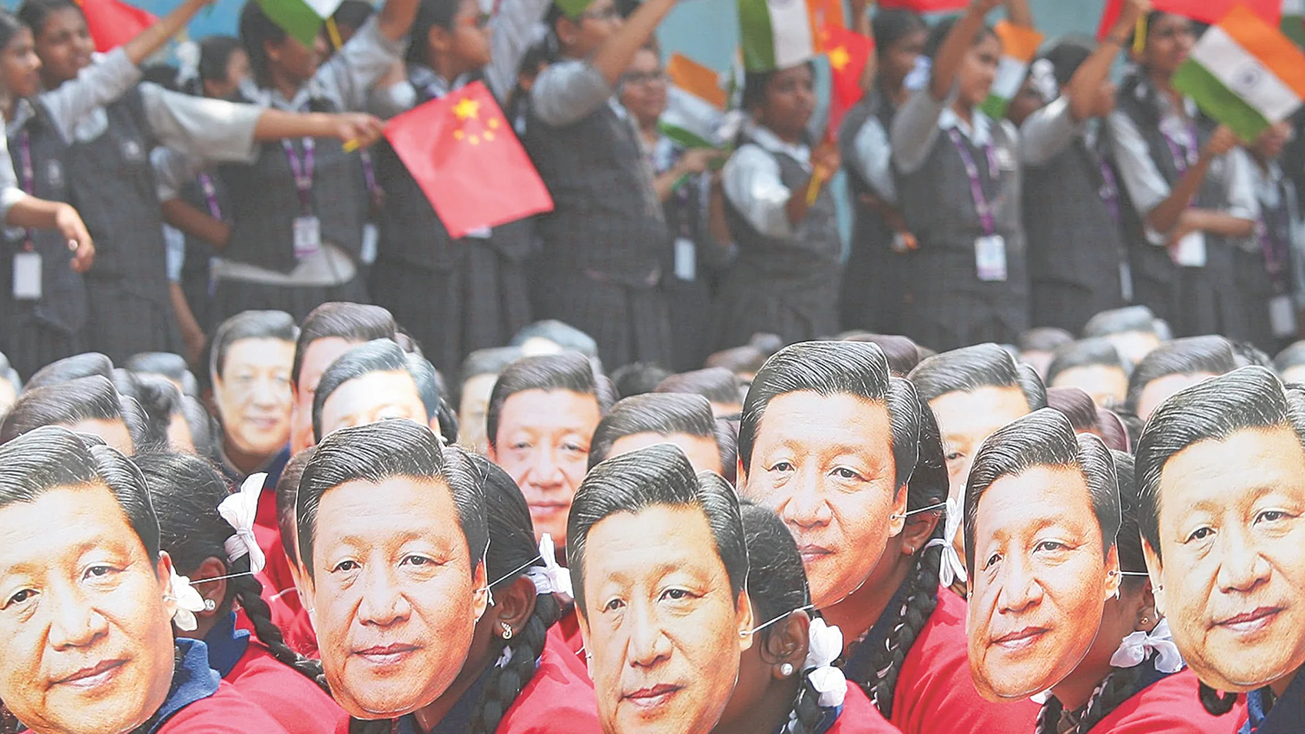 Varios estudiantes con una careta del presidente de China, Xi Jinping, en un congreso en India