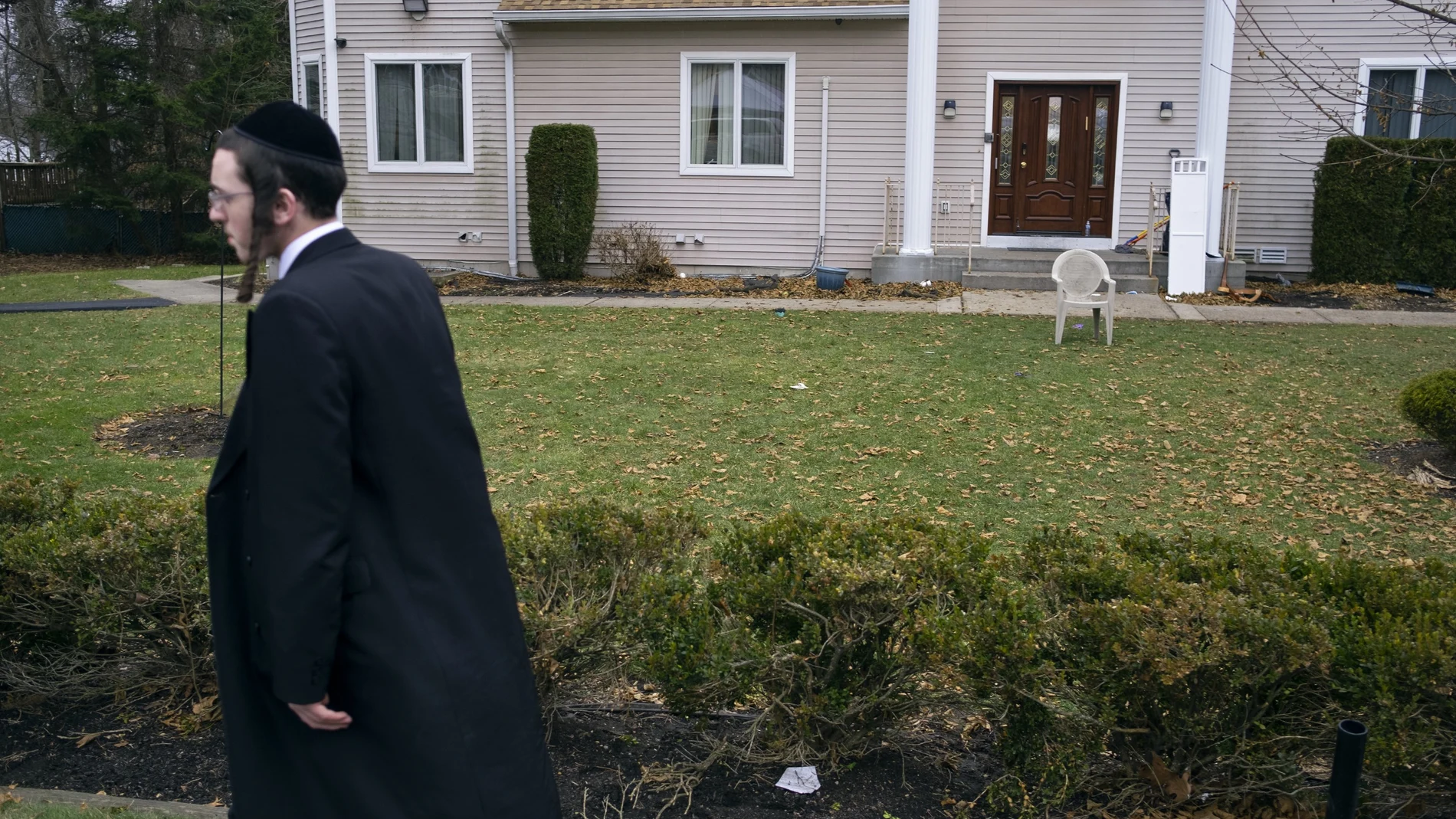 Un miembro de la comunidad judía pasa delante de la casa del rabino donde cinco personas fueron apuñaladas en Monsey, Nueva York.