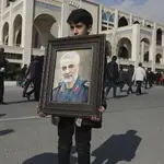 Un niño iraní muestra una pancarta con la cara del militar Soleimani