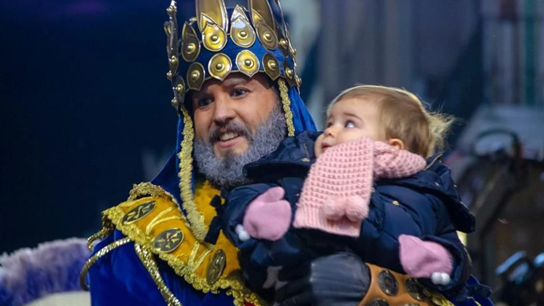 El Rey Melchor junto a una pequeña en la cabalgata de 2019