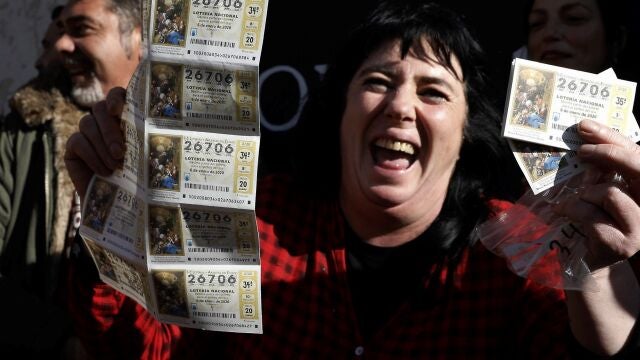 Varias personas festejan con sus décimos el tercer premio del Sorteo extraordinario de El Niño de 2020.