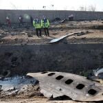 Miembros de los servicios de emergencia observan parte del fuselahe del Boeing 737 de la compañía ucraniana UIA que se ha estrellado esta madrugada en Teherán (Israel). Nacionales de siete países, entre ellos 63 canadienses, han muerto en el accidente aéreo. EFE/ Abedin Taherkenareh