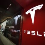 FILE - This Feb. 9, 2019, file photo shows a sign bearing the company logo outside a Tesla store in Cherry Creek Mall in Denver. The U.S. government's road safety agency is sending a special team to Indiana to investigate a fatal crash involving a Tesla electric vehicle. The National Highway Traffic Safety Administration said Wednesday, Jan. 8, 2020, that its team will check the crash scene and inspect the Model 3 vehicle involved in the Dec. 29 crash with a parked firetruck on Interstate 70 near Terre Haute. (AP Photo/David Zalubowski, File)