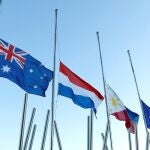 Banderas de diferentes países lucen a media asta frente a la embajada de Australia.