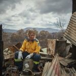 Una bombera voluntaria descansa en los restos de su casa en Verona, Australia