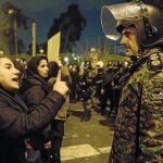 Estudiantes que acudieron a una vigilia en recuerdo de las víctimas del avión ucraniano hablan con un policía en la Universidad Amri Kabir, ayer, en Teherán