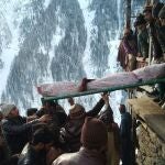 Imagen de pakistaníes trasladando el cadaver de una víctimas de las avalanchas. REUTERS/Stringer