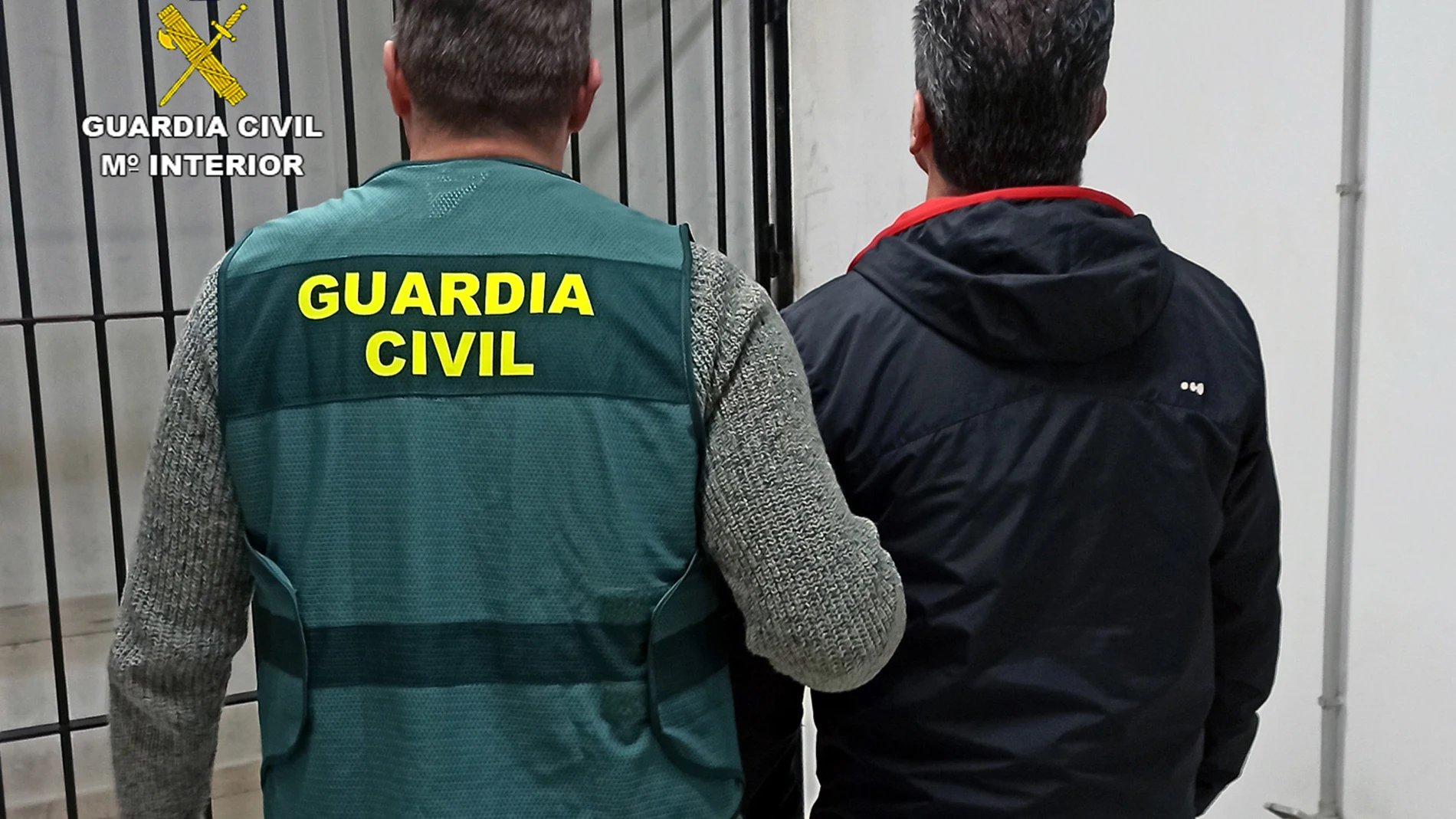 El detenido es conducido al calabozo por un agente de la Guardia Civil