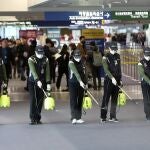 Trabajadores rocían una solución antiséptica en el lobby de llegadas del aeropuerto en medio de la creciente preocupación pública por la posible propagación del nuevo coronavirus. (Suh Myung-geon/Yonhap via AP)
