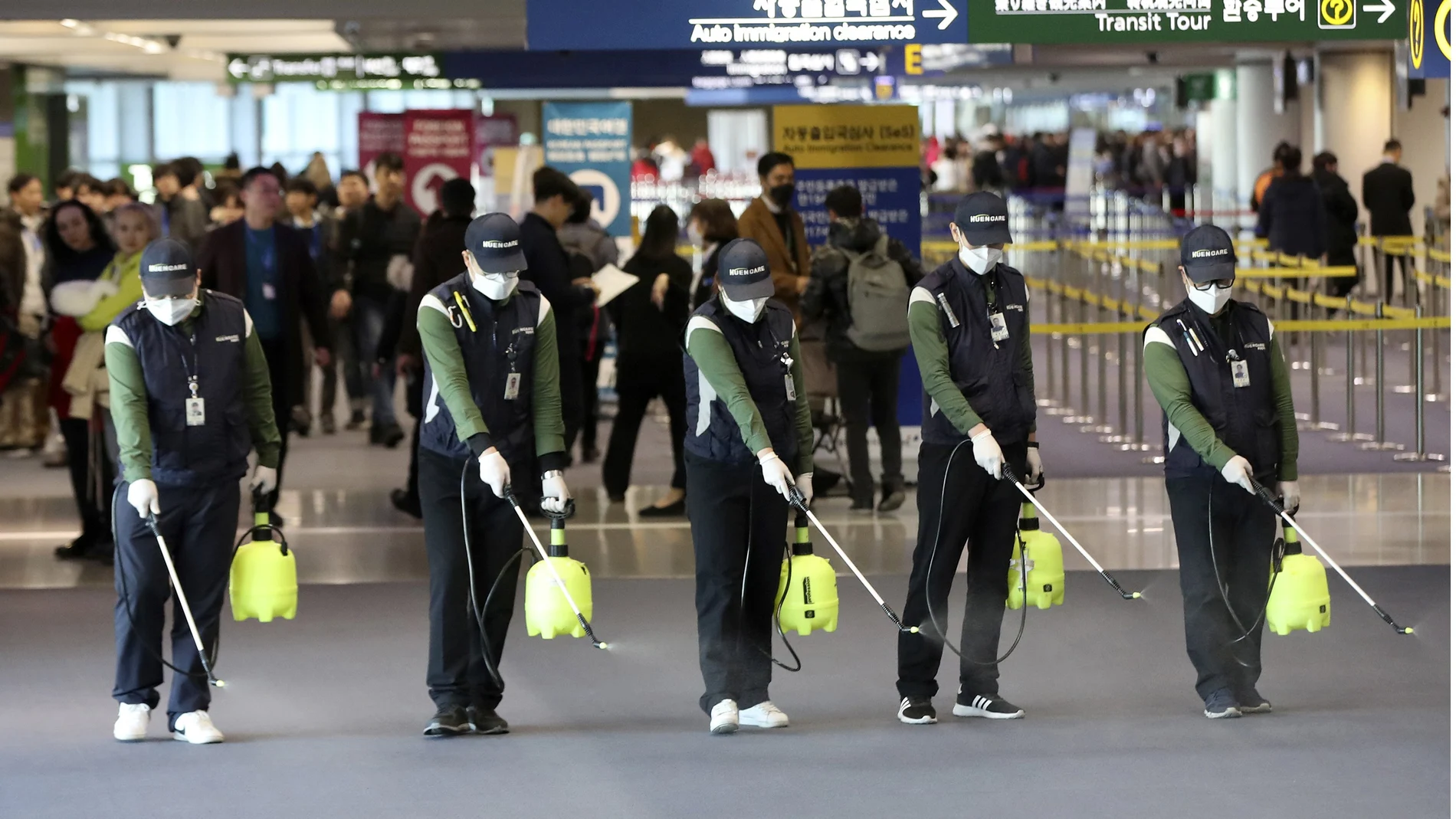 Trabajadores rocían una solución antiséptica en el lobby de llegadas del aeropuerto en medio de la creciente preocupación pública por la posible propagación del nuevo coronavirus. (Suh Myung-geon/Yonhap via AP)