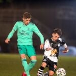 El delantero de Unionistas de Salamanca Álvaro Romero (d) juega un balón ante Valverde, del Real Madrid, durante el partido de dieciseisavos de final de la Copa del Rey que se disputa este miércoles en Las Pistas del Helmántico, en Salamanca. EFE/J.M. García